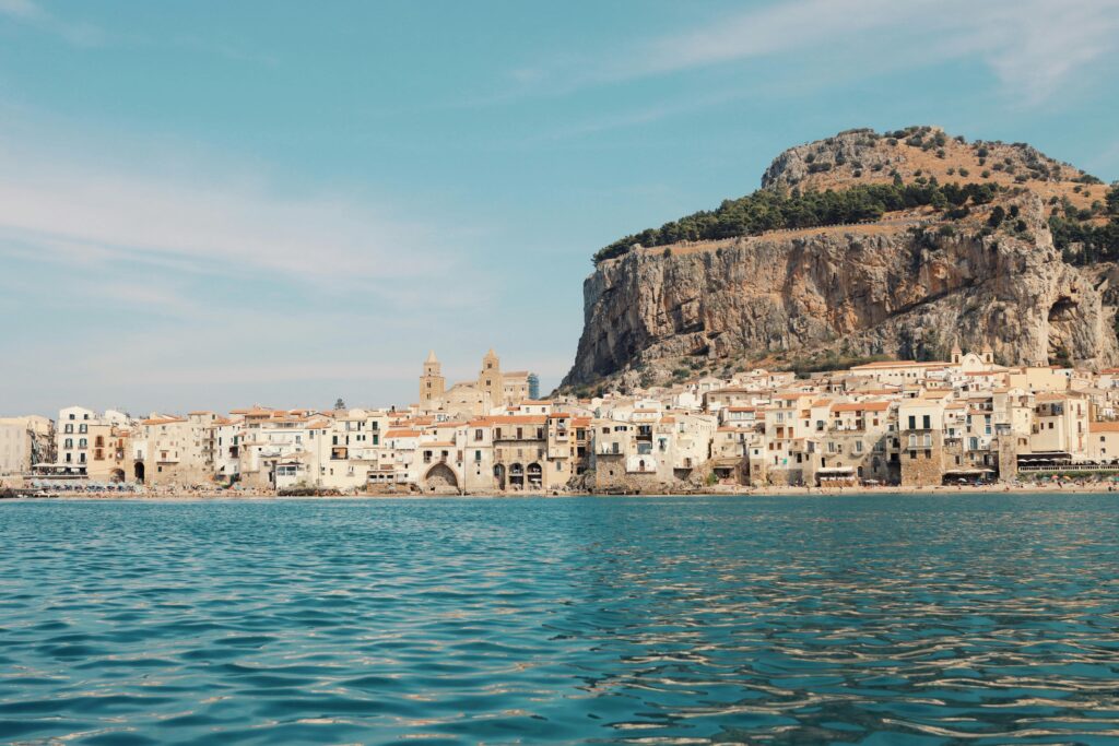 Explore the picturesque coastal town of Cefalù with its stunning beaches and rocky cliffs in Sicily.