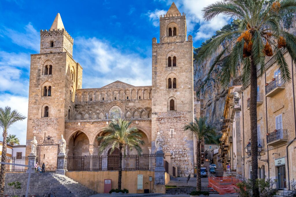 Stunning view of the historic Cefalù Cathedral in Sicily, Italy, under a bright blue sky.