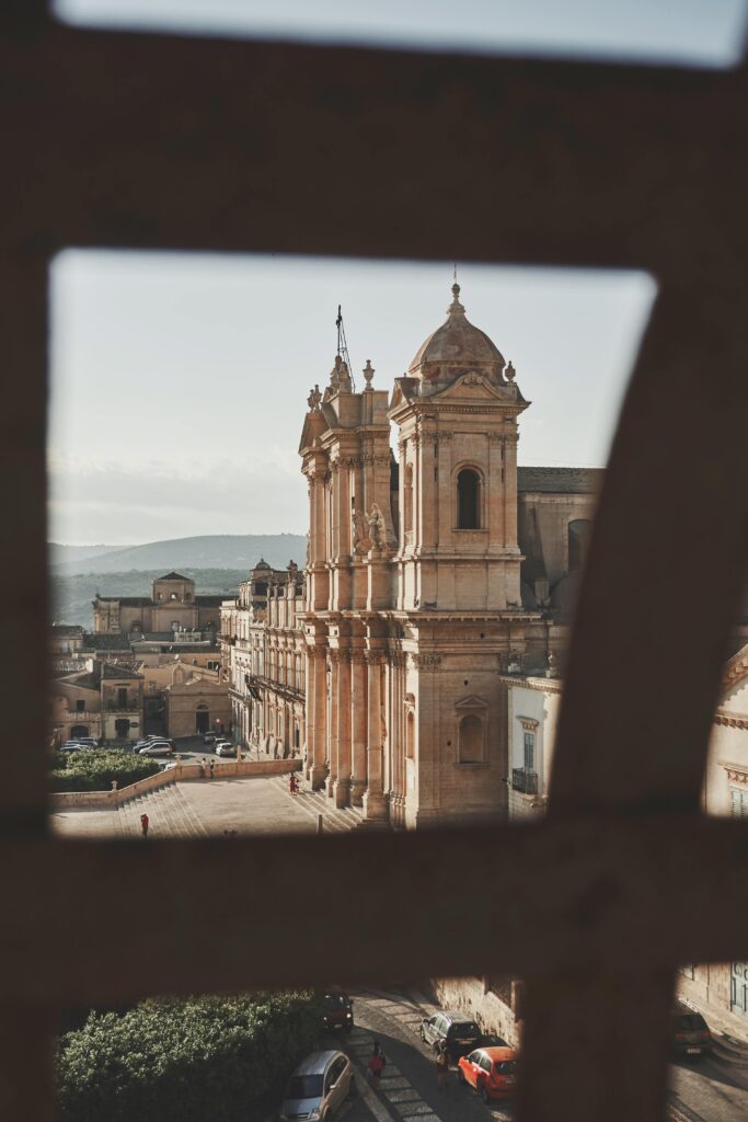 pexels-photo-1496448-1496448 Beautiful baroque architecture of Noto Cathedral in Sicily, Italy, viewed through a window frame.